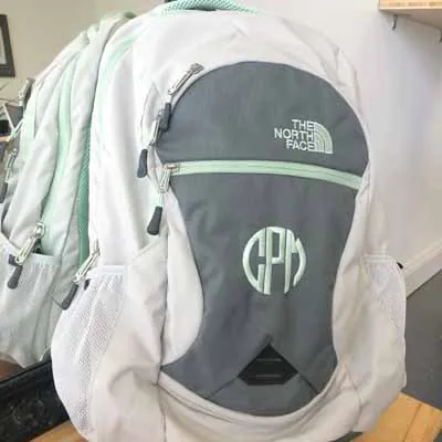 Monogram embroidered on a grey North Face backpack