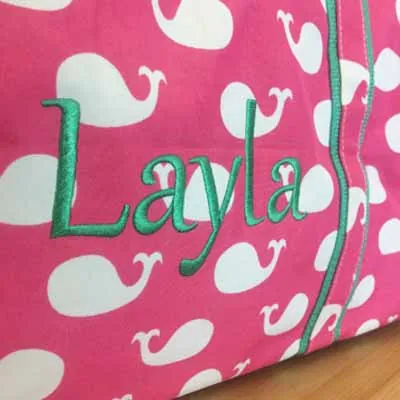 Name Layla embroidered on a pink whale-print bag