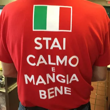Stai Calmo e Mangia Bene screen printed on a red t-shirt